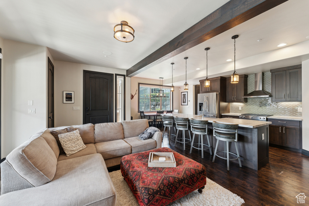 Living room with dark wood-type flooring, beam ceiling, and recessed lighting