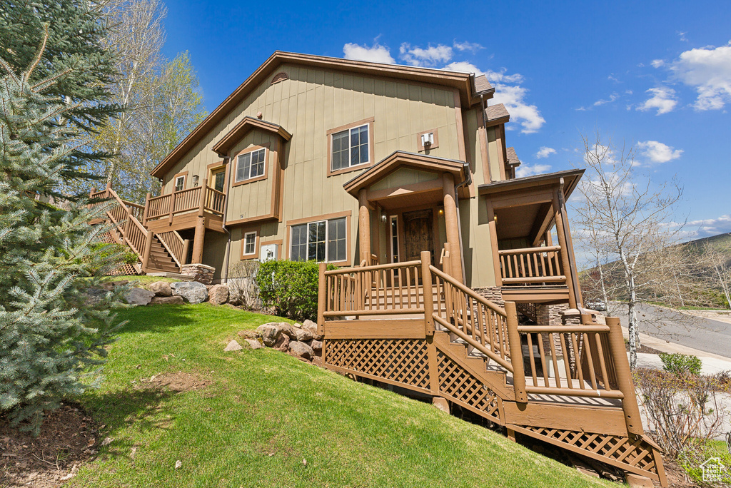 Back of house featuring stairs and a yard