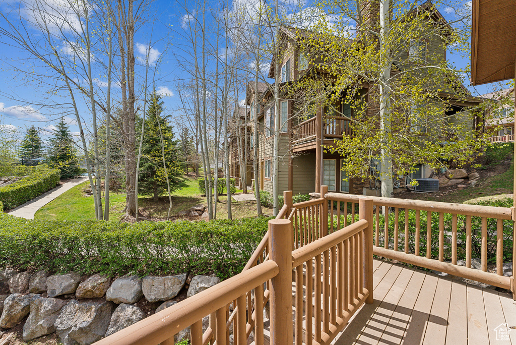 Wooden terrace featuring cooling unit