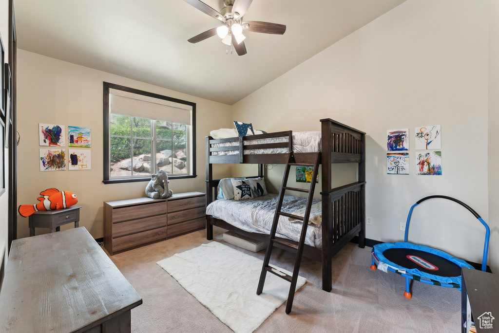 Carpeted bedroom with lofted ceiling and ceiling fan