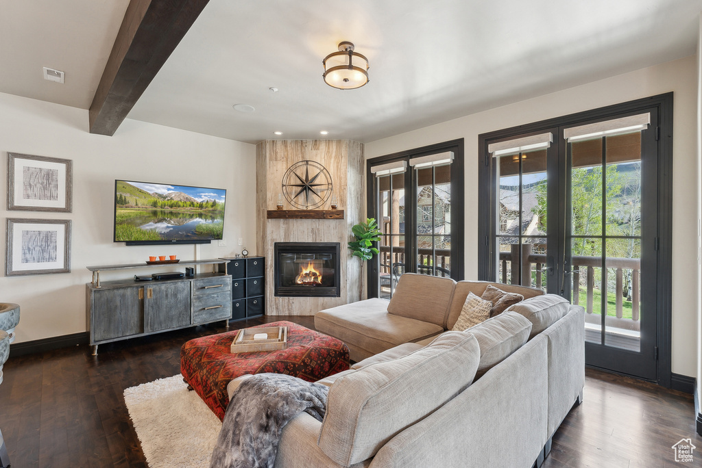 Living area featuring a fireplace, baseboards, dark wood finished floors, beamed ceiling, and recessed lighting