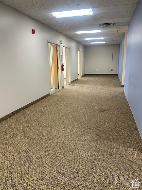 Carpeted empty room featuring a paneled ceiling