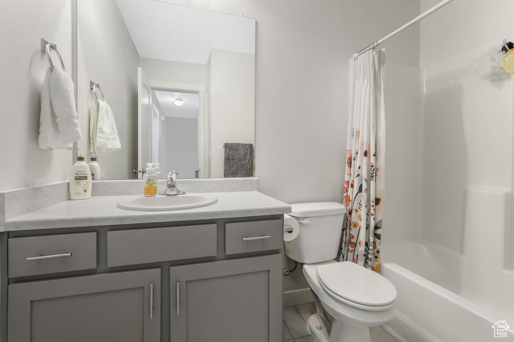 Bathroom with toilet, vanity, and shower / bath combo with shower curtain