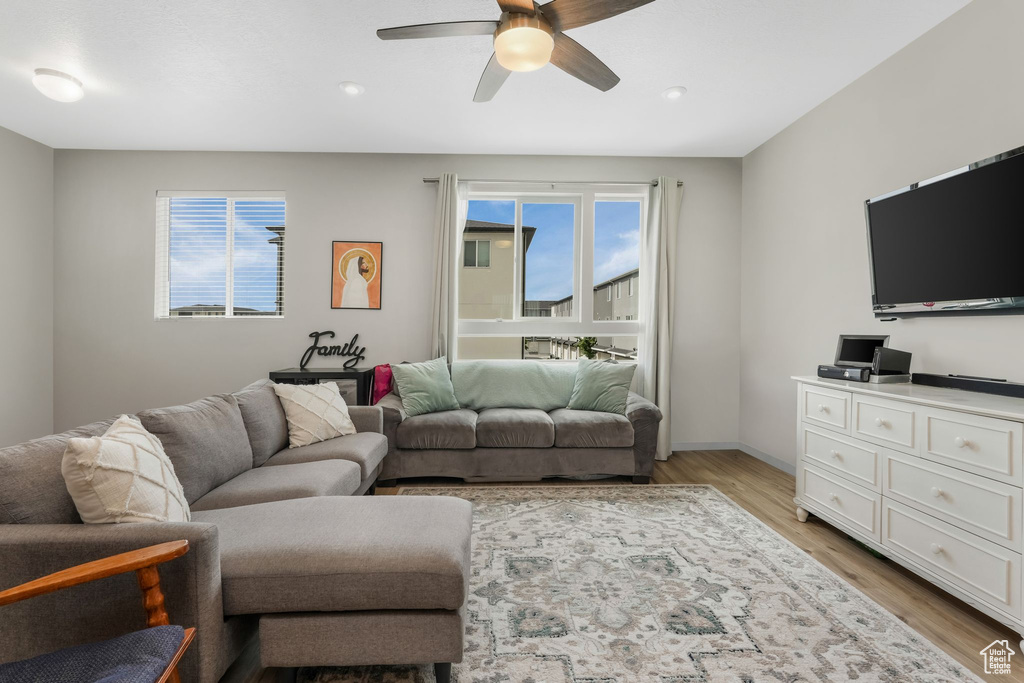 Living area featuring ceiling fan, light wood-style flooring, recessed lighting, and baseboards