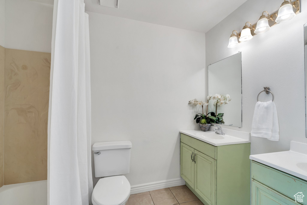 Bathroom featuring tile patterned flooring, vanity, toilet, shower / tub combo with curtain, and baseboards