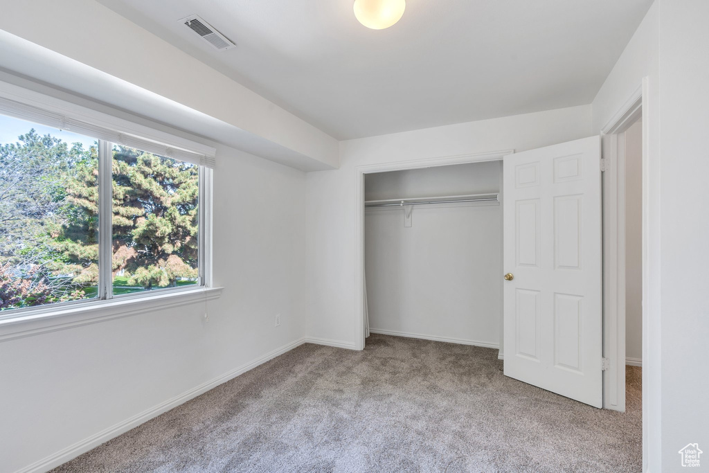 Unfurnished bedroom featuring carpet flooring, a closet, and baseboards