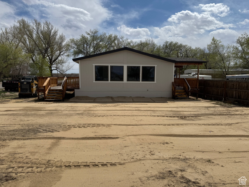 Back of property with fence and a deck