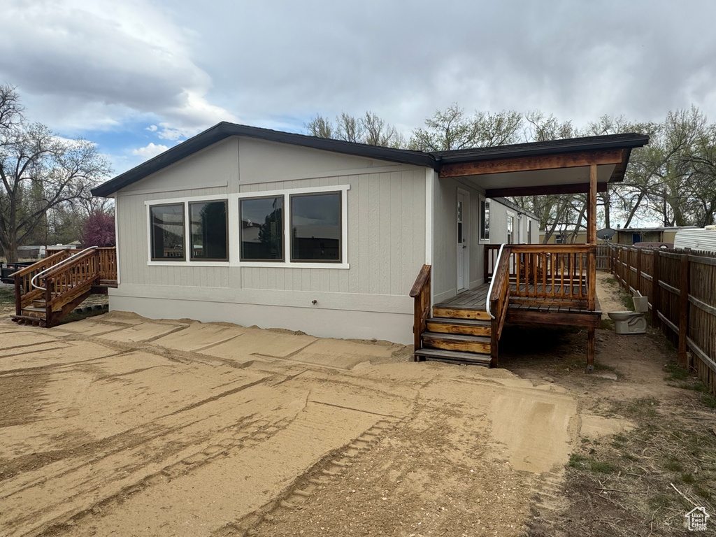 Back of property with fence and a wooden deck