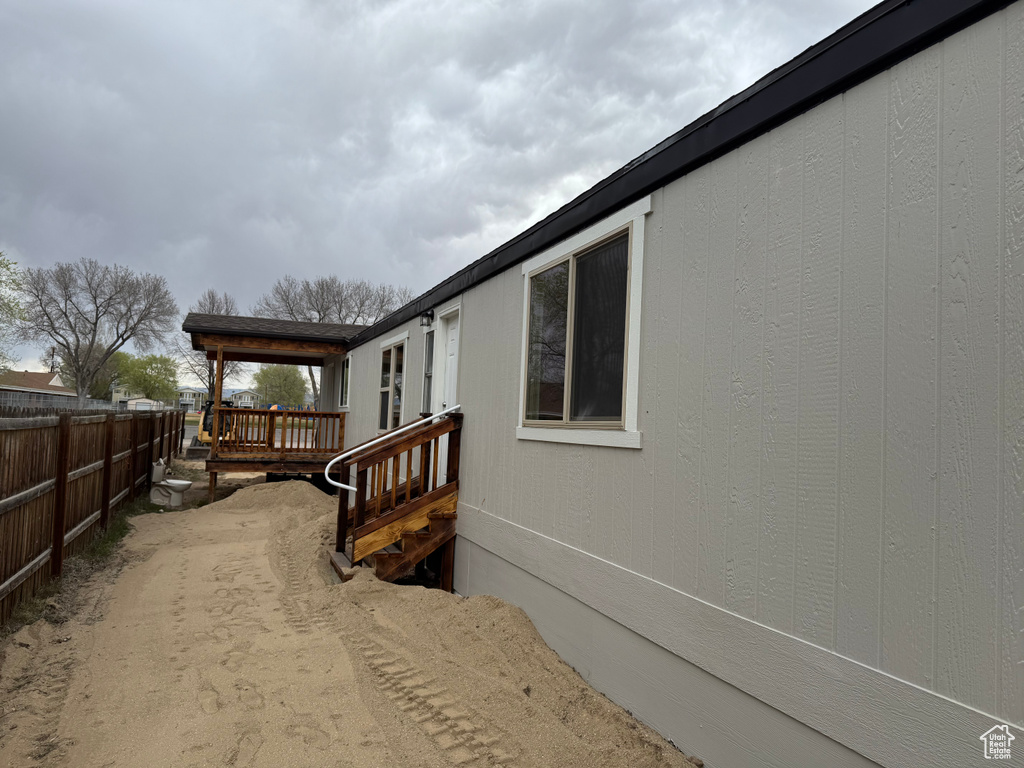 View of side of home with fence and a deck