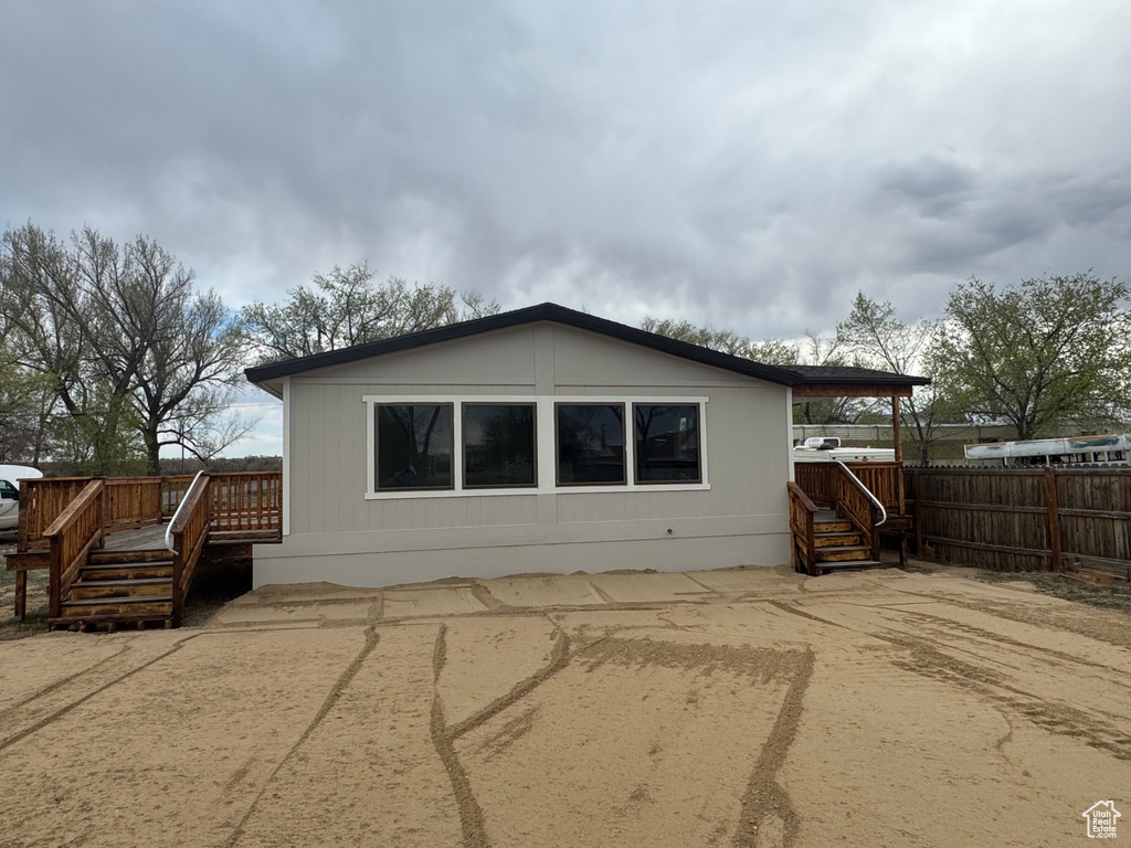 Rear view of house with fence and a wooden deck