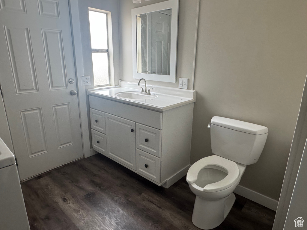 Bathroom with toilet, wood finished floors, and vanity