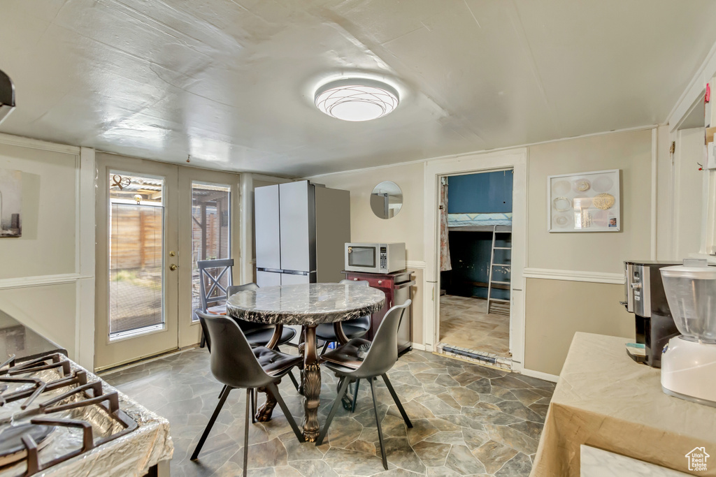 Dining area featuring stone finish flooring and baseboards