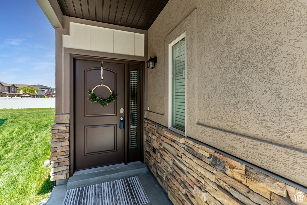 Property entrance featuring stucco siding and a yard