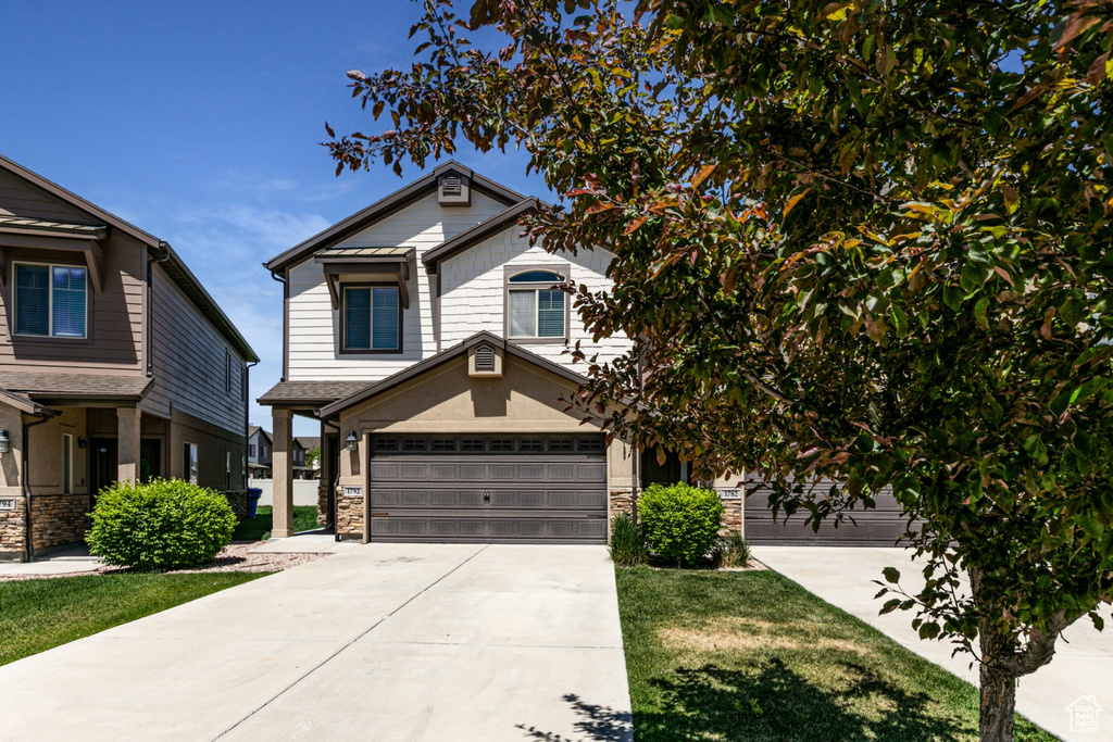 View of front of property featuring driveway and stone siding