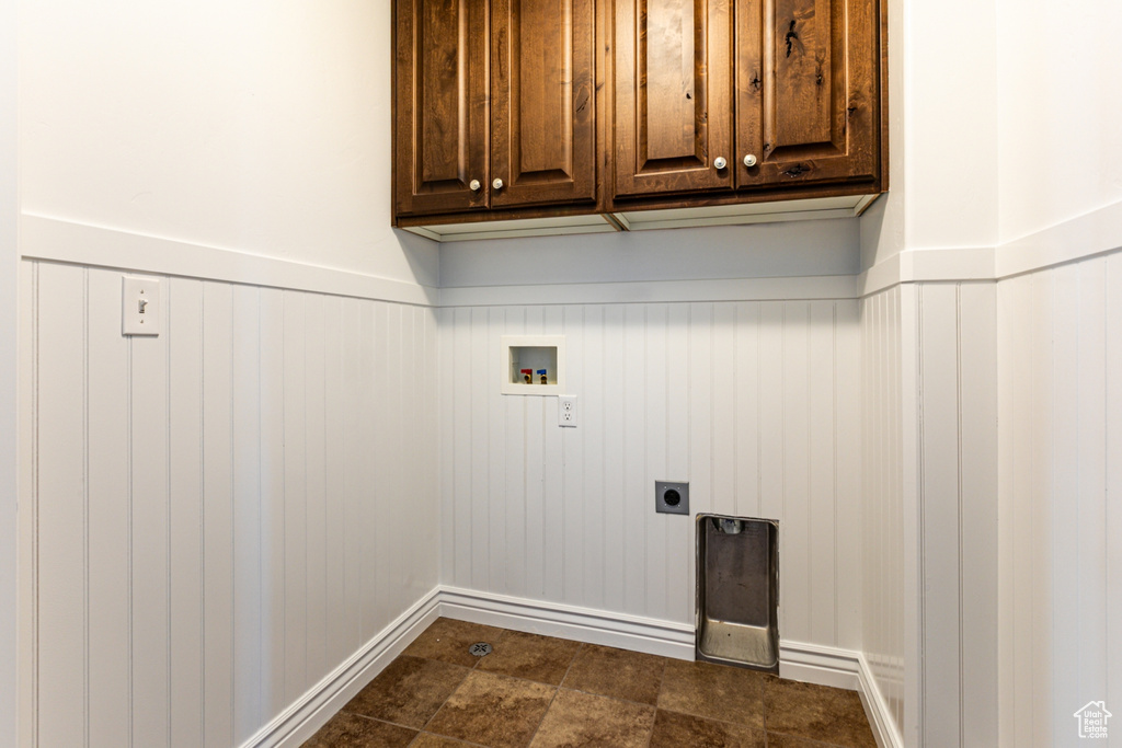 Washroom with hookup for a washing machine, electric dryer hookup, cabinet space, wainscoting, and baseboards