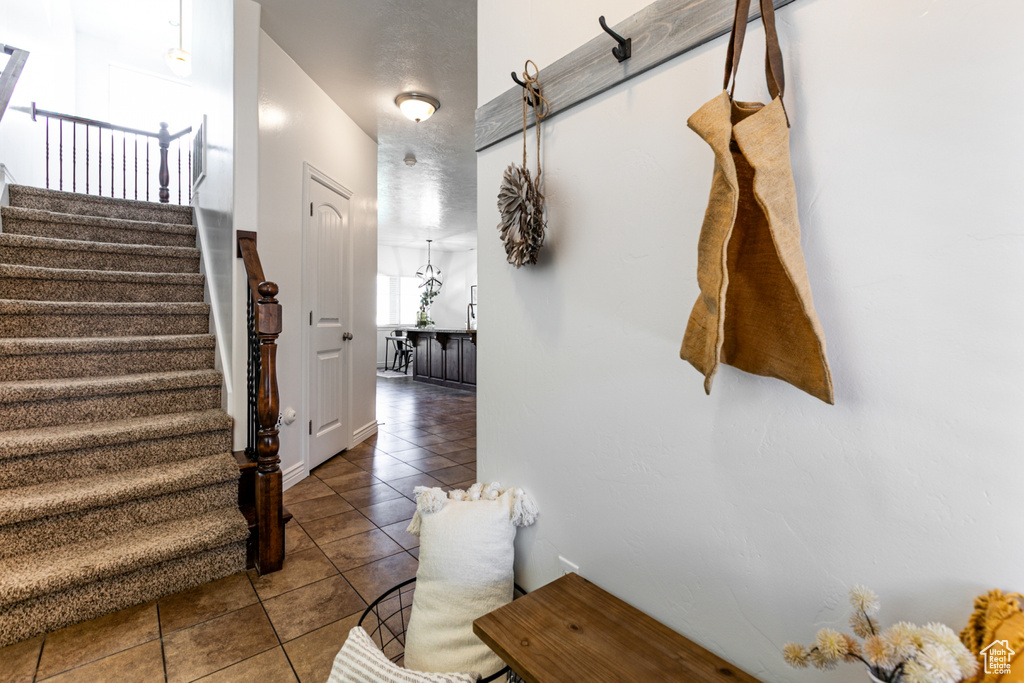 Foyer entrance with tile patterned floors and stairs