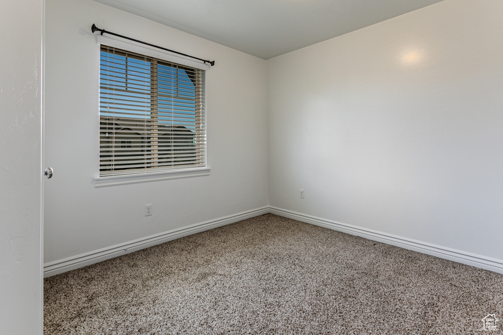 Carpeted empty room featuring baseboards