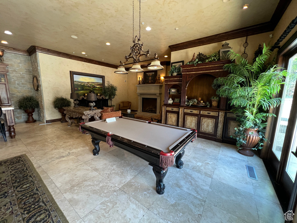 Rec room with healthy amount of natural light, crown molding, billiards table, a fireplace, and recessed lighting