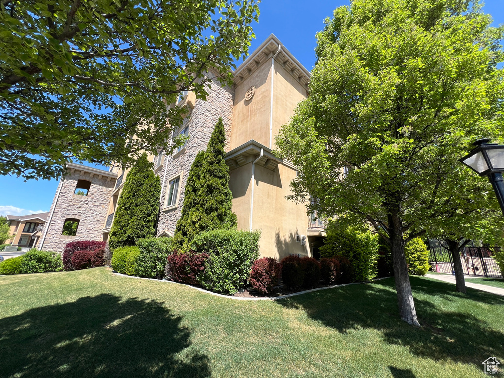 View of home\'s exterior with stucco siding, stone siding, and a yard