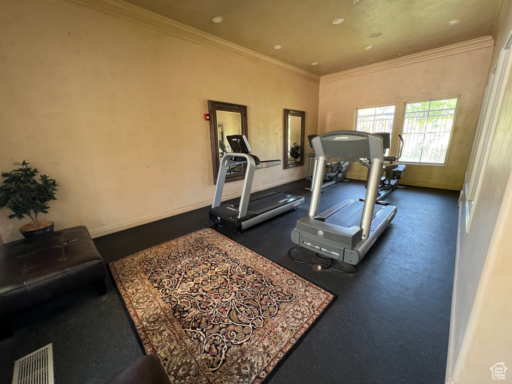 Workout room featuring crown molding and baseboards