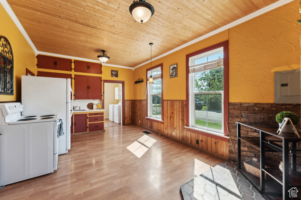 Kitchen featuring white range with electric cooktop, crown molding, a wainscoted wall, wood ceiling, and washer / dryer