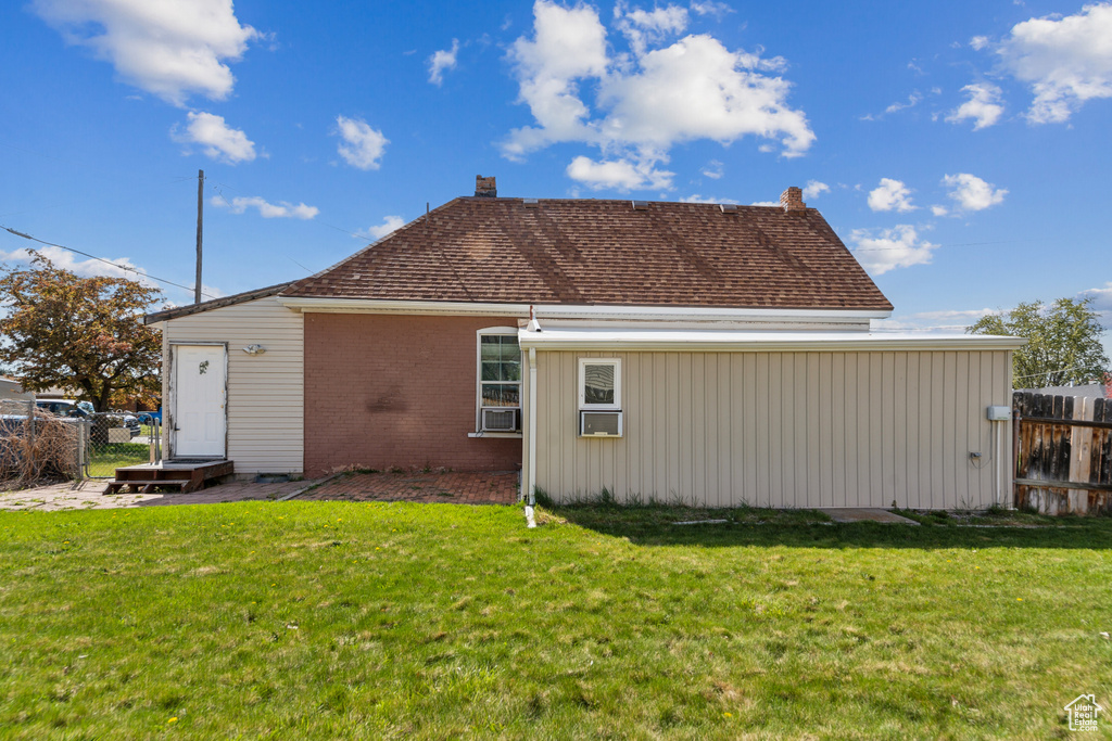 Rear view of property with brick siding, a chimney, and roof with shingles