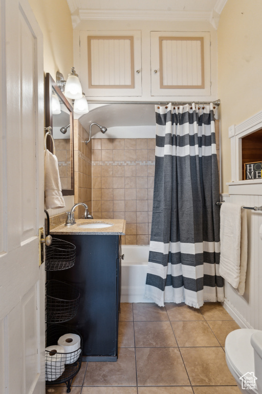 Bathroom featuring tile patterned floors, shower / bath combination with curtain, vanity, crown molding, and toilet