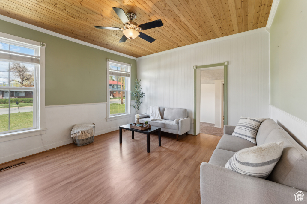 Living room with crown molding, wood ceiling, light wood-style flooring, and a ceiling fan