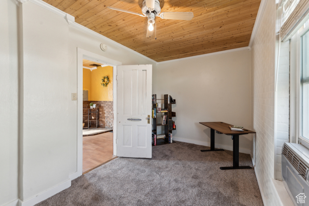 Interior space featuring crown molding, carpet, ceiling fan, wood ceiling, and baseboards
