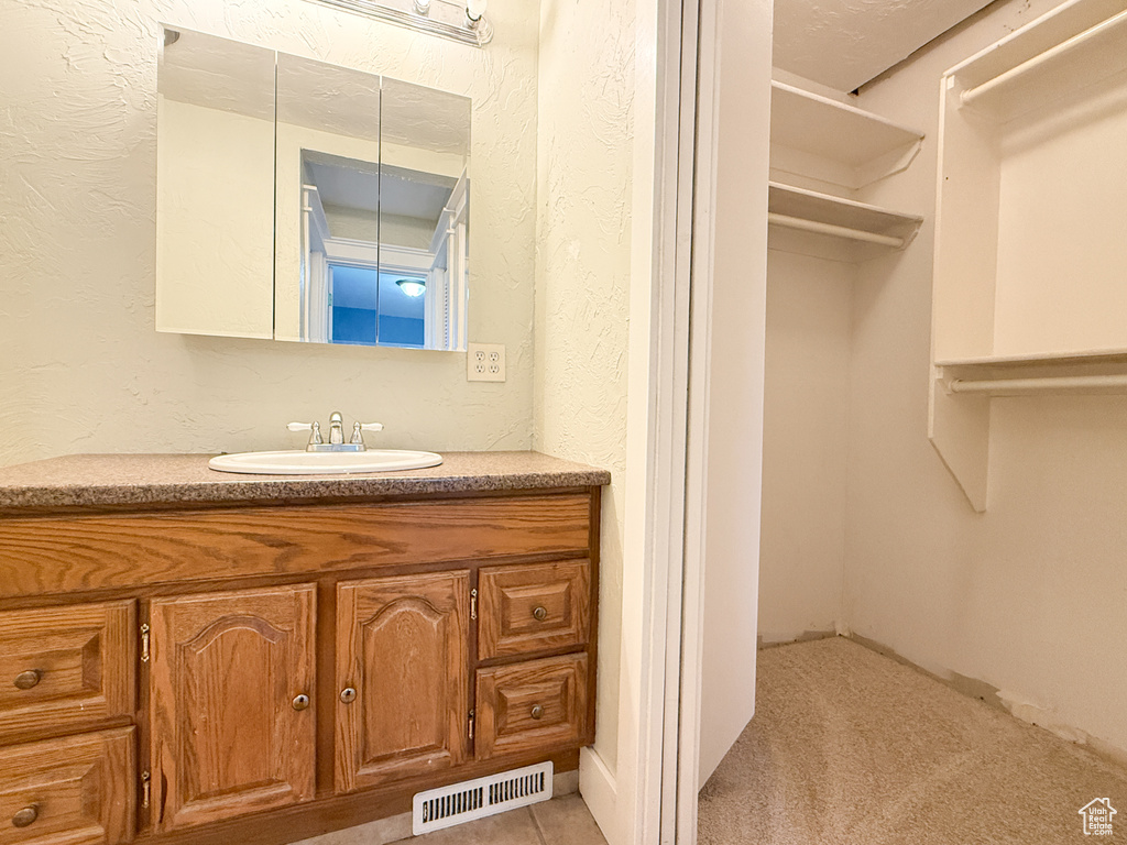 Bathroom with vanity and a textured wall