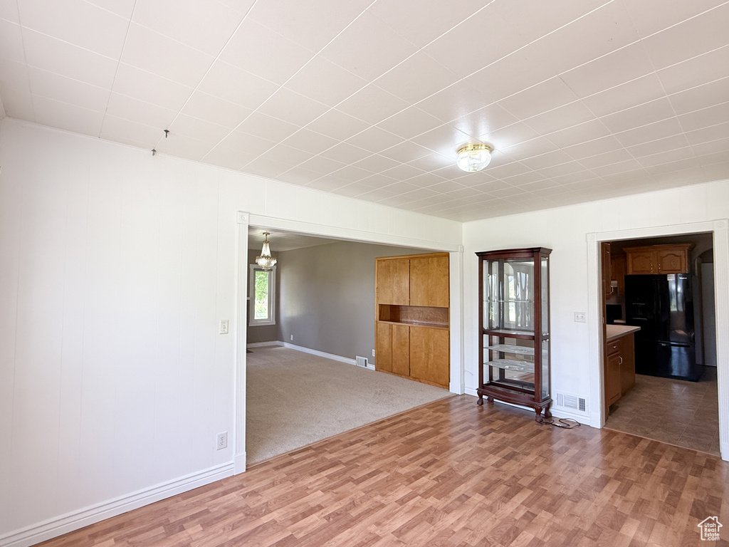 Unfurnished living room featuring light wood finished floors and baseboards