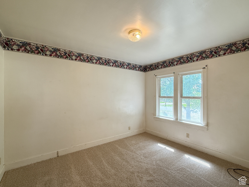 Spare room with light carpet and baseboards