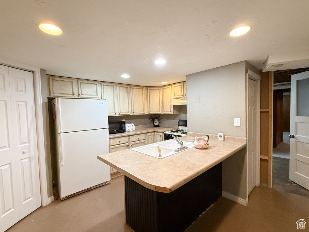 Kitchen with white appliances, light countertops, a peninsula, recessed lighting, and finished concrete floors