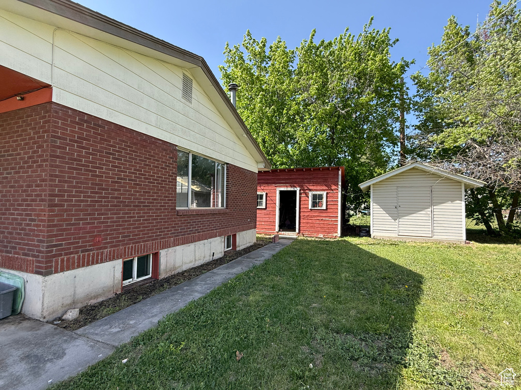 View of home\\\\\\\\\\\\\\\\\\\\\\\\\\\\\\\'s exterior featuring a lawn, brick siding, and an outdoor structure