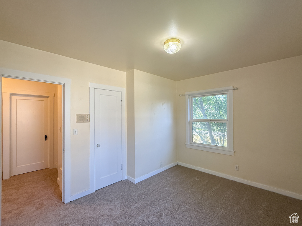 Unfurnished bedroom featuring carpet flooring and baseboards