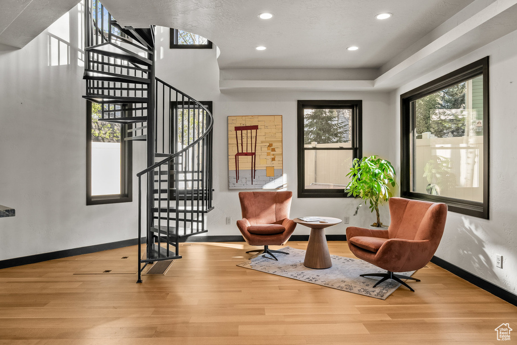 Living area featuring wood finished floors, stairs, recessed lighting, and baseboards