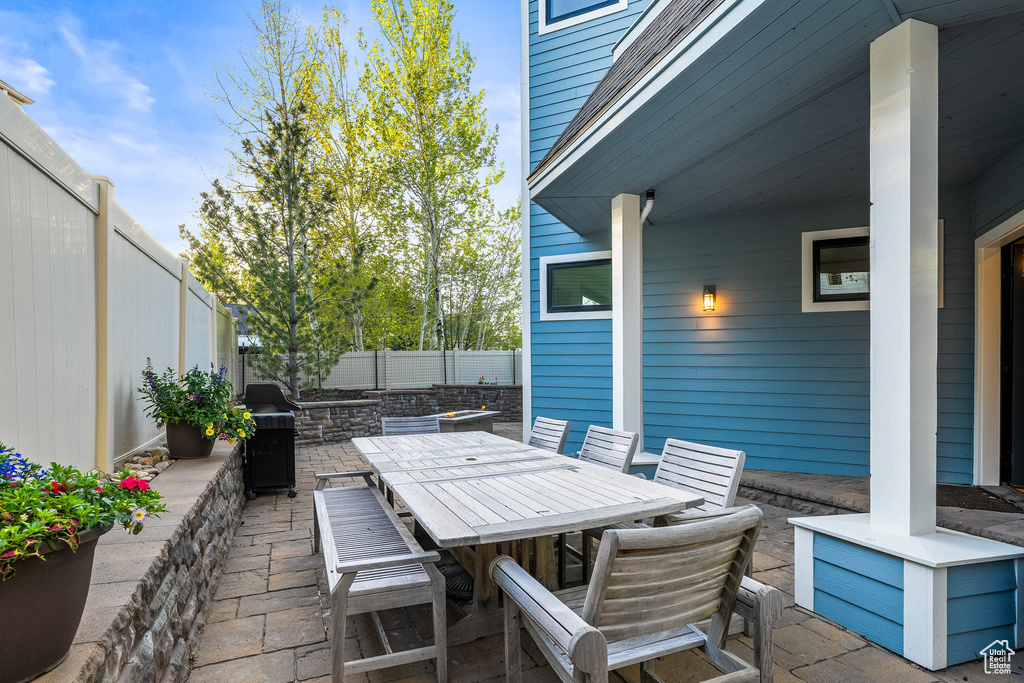 View of patio with a fenced backyard, outdoor dining space, and area for grilling
