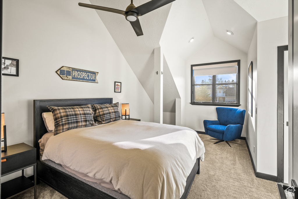 Bedroom with vaulted ceiling, light carpet, a ceiling fan, and baseboards