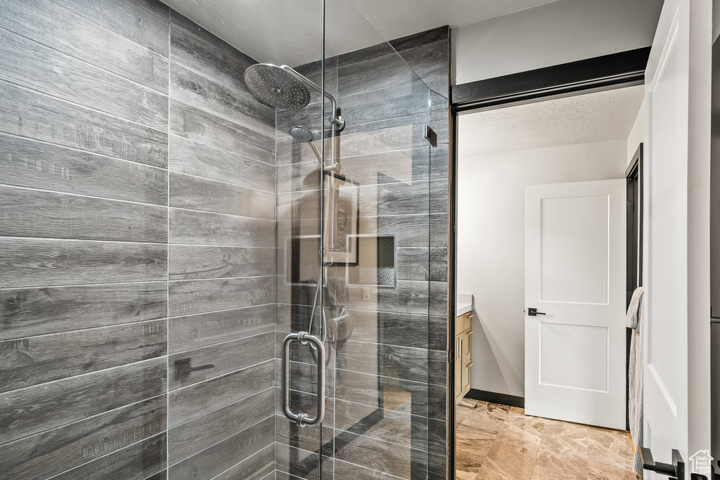 Bathroom featuring tiled shower and vanity