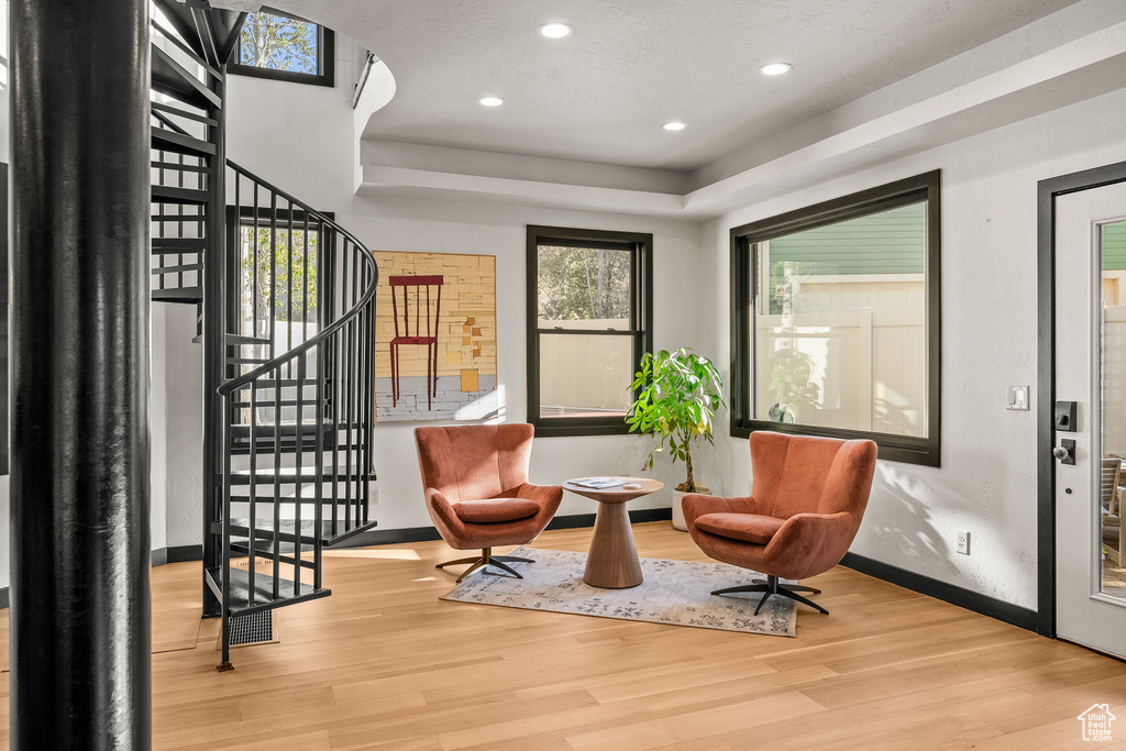 Sitting room featuring wood finished floors, baseboards, stairs, recessed lighting, and a tray ceiling