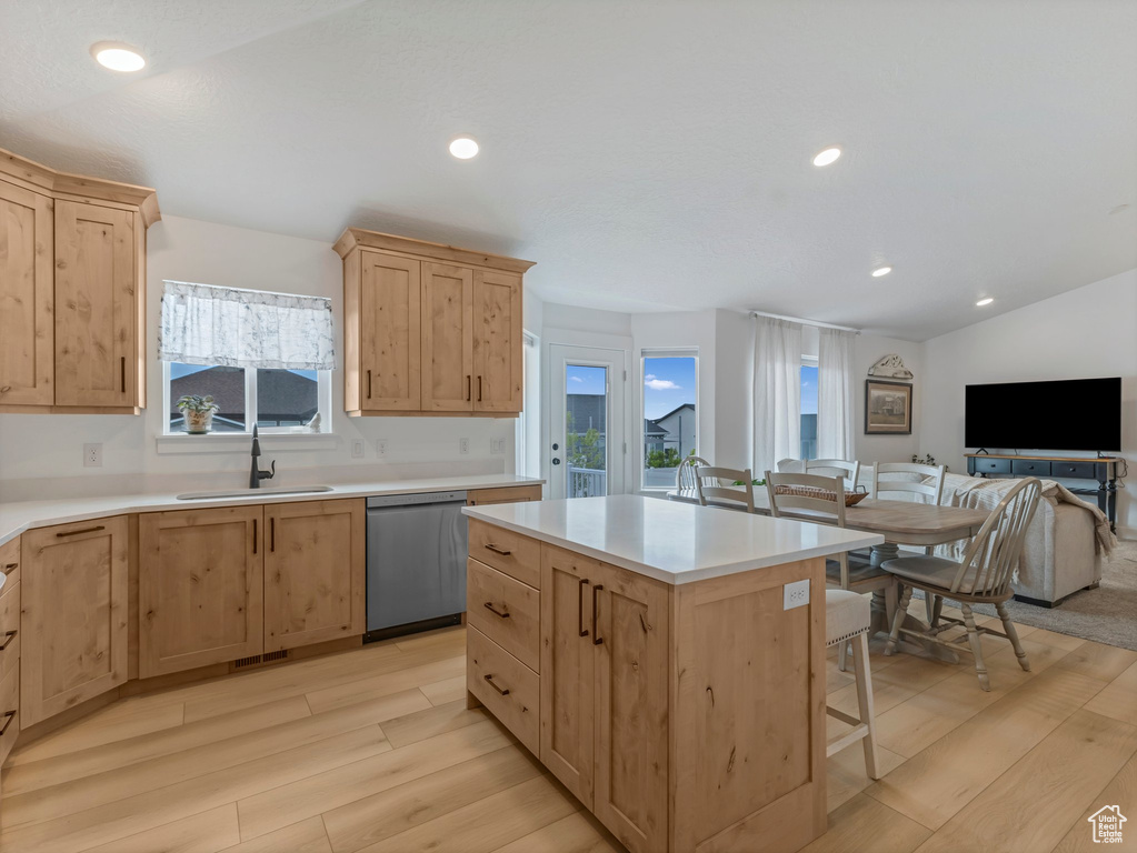 Kitchen with stainless steel dishwasher, a sink, light brown cabinetry, light wood-style flooring, and recessed lighting