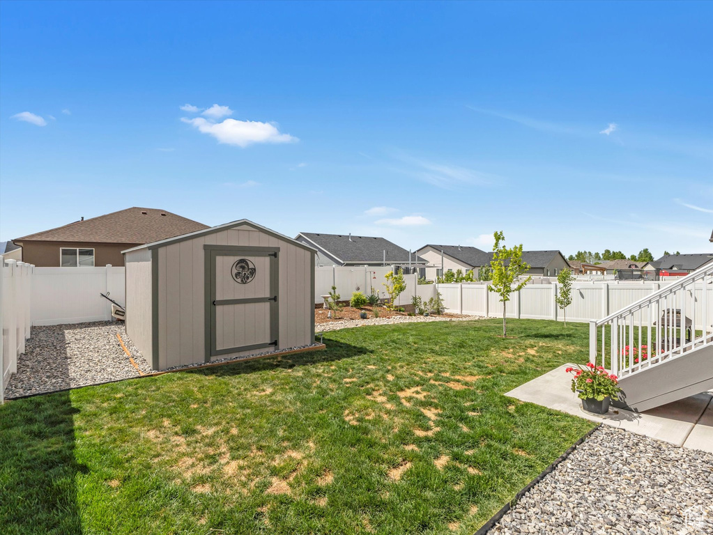 View of yard with a shed, a residential view, an outbuilding, and a patio