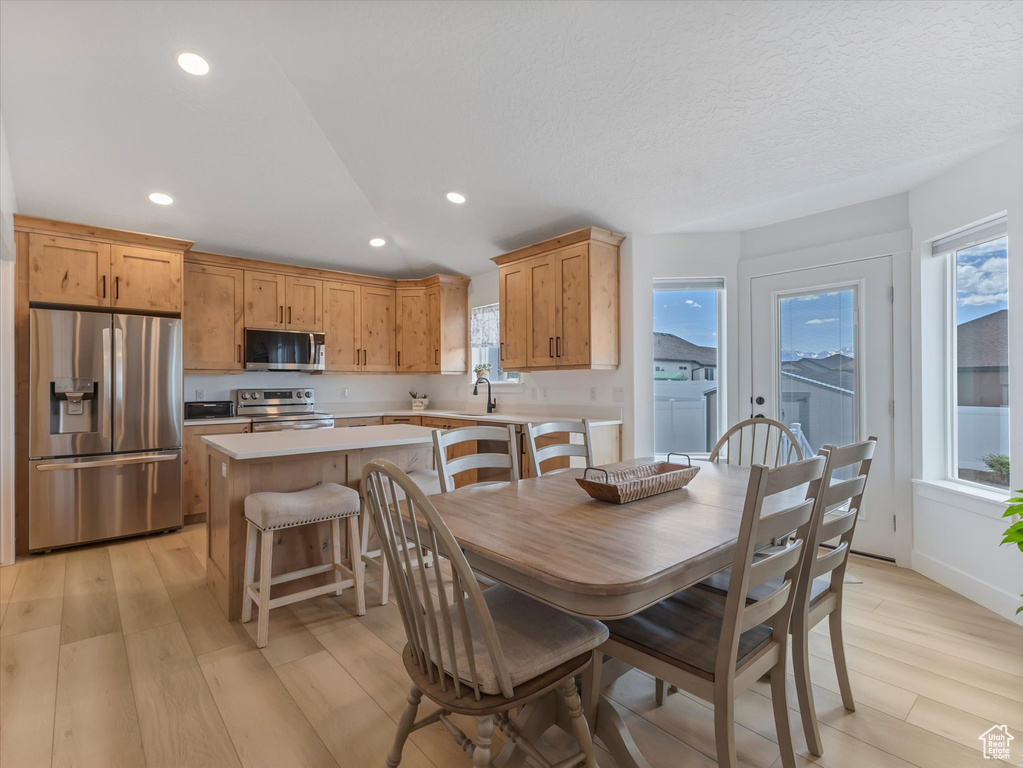 Dining area featuring light wood finished floors, plenty of natural light, and recessed lighting