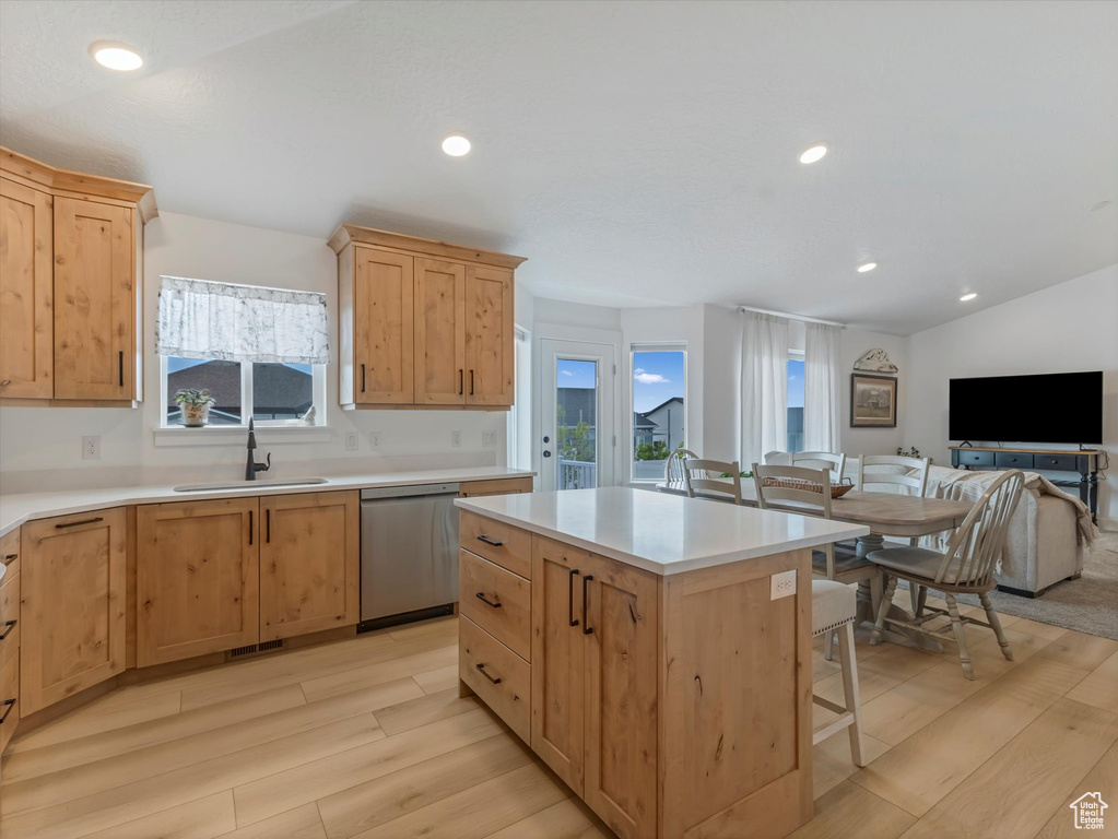 Kitchen with a sink, dishwasher, light wood-style flooring, light brown cabinetry, and open floor plan