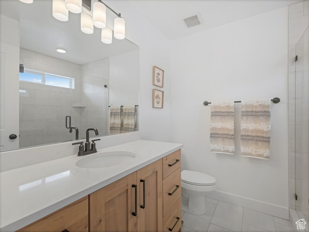 Full bathroom with vanity, a stall shower, toilet, and baseboards