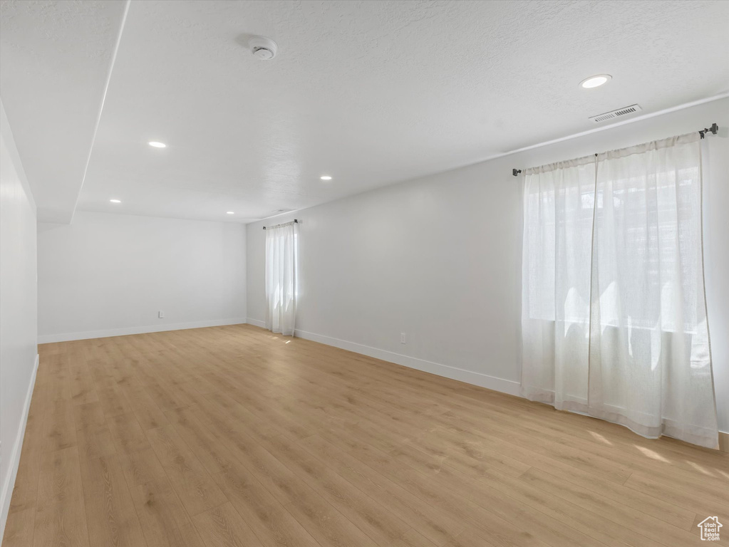 Empty room with recessed lighting, a smoke detector, light wood-style floors, and baseboards