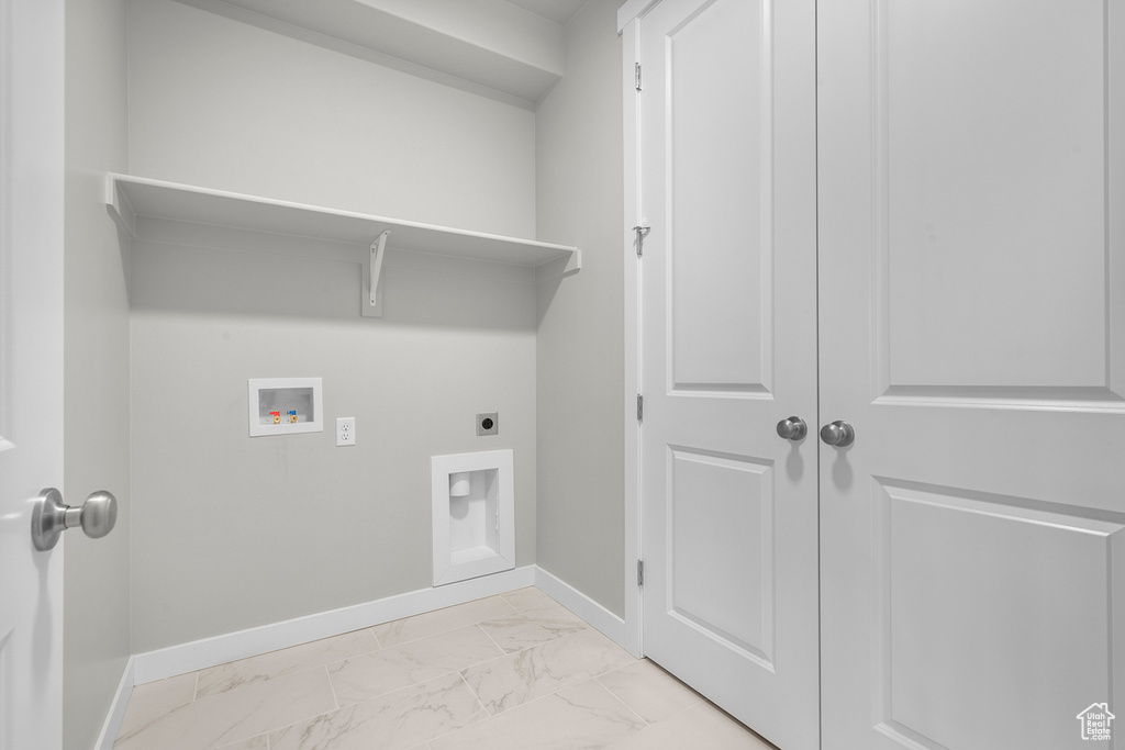Clothes washing area featuring hookup for an electric dryer, light marble finish floors, baseboards, and washer hookup