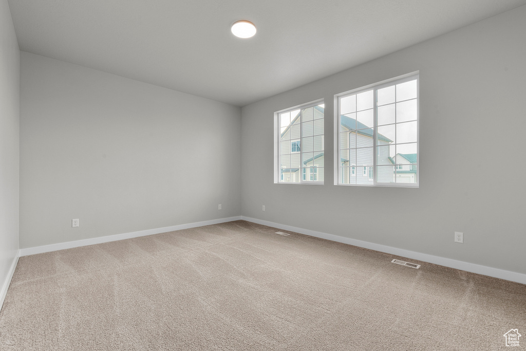 Carpeted empty room featuring baseboards