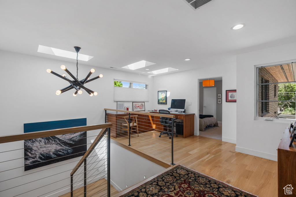 Office with a skylight, a chandelier, light wood-style flooring, plenty of natural light, and recessed lighting