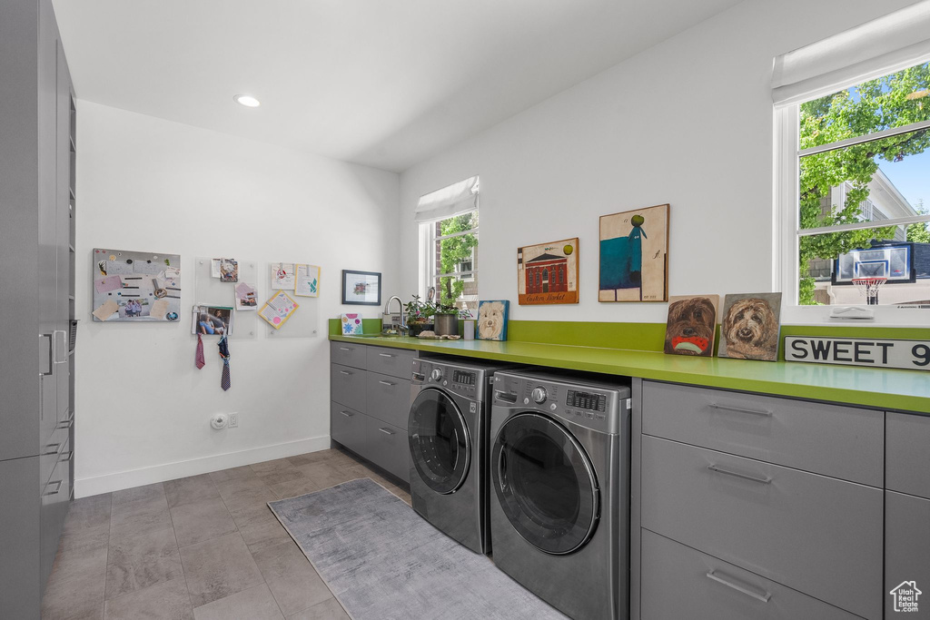 Washroom featuring washing machine and clothes dryer, baseboards, recessed lighting, and cabinet space